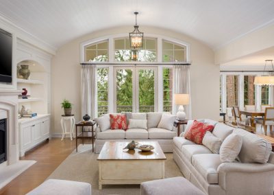 cozy living room with light beige couch and loveseat with large window in the background